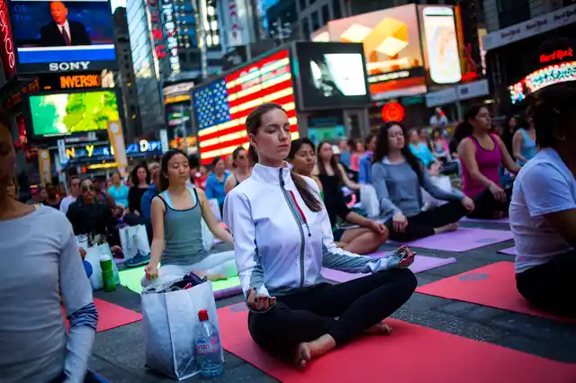 People practice yoga in Times Square as part of a Summer Solstice celebration in New York. (Photo: Reuters)
