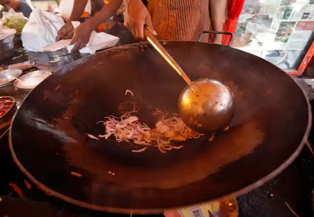 Onions being fried to put into vegetable chowmein at a beachside Mumbai restaurant. (Photo: Reuters) 