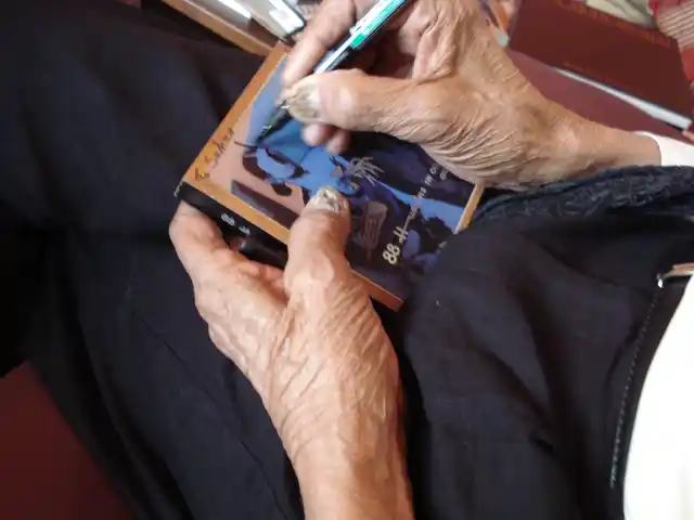 MF Husain signs a poster for Sahar Zaman. (Courtesy: Sahar Zaman)