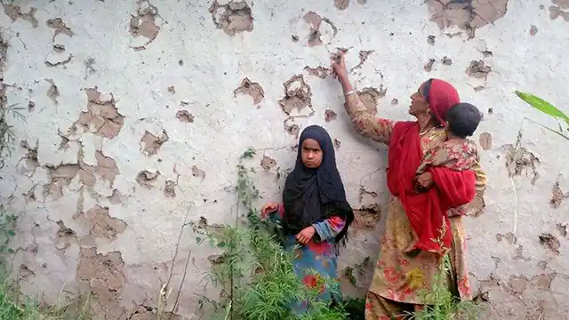 Villagers look at splinter marks on a house after a ceasefire violation by Pakistan in the Shahpur sector near the Line of Control in Jammu and Kashmir’s Poonch district. (Photo: PTI)