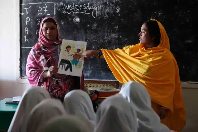 Teachers display a card with an illustration depicting a girl going through a medical check-up by a doctor, as they describe preventive measures to avoid when sexual harassment occurs (Photo: Reuters)