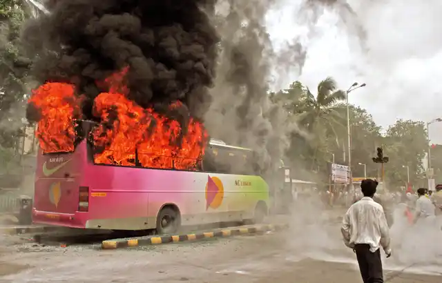 Members of Shiv Sena party pelt buses with stones, shut shops and block sections of a major highway in Mumbai on July 9, 2006 after a statue of the party leader’s wife was defaced. (Photo: Reuters)
