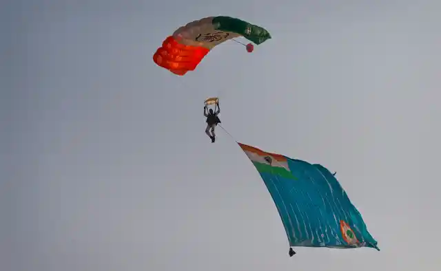 A member of an Indian Air Force (IAF) Akash Ganga skydiving team dives with an IAF flag during the Air Force Day parade at Hindon Air Force base near New Delhi. (Photo: AP)