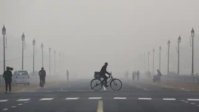 A newspaper vendor rides his bicycle on a smoggy morning in New Delhi, December 1, 2015. (Photo: Reuters)
