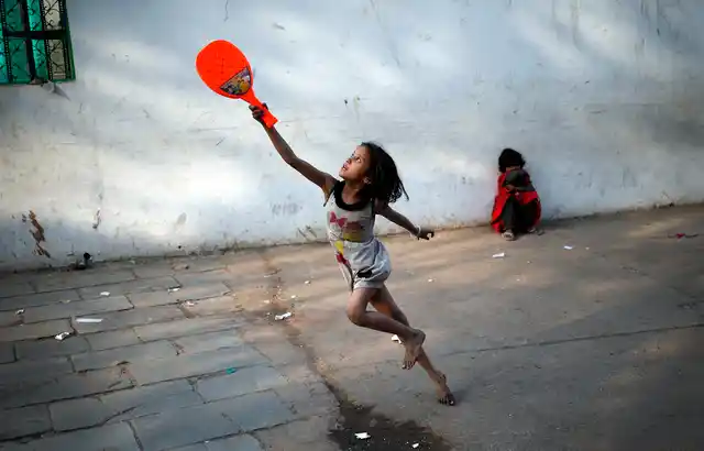 A child plays with a plastic badminton racket in the old quarters of Delhi, 3 March 2016. (Photo: Reuters/Anindito Mukherjee)