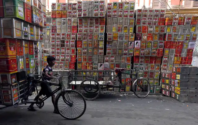 A man pushes a bicycle loaded with empty cooking oil containers at a road side workshop in Kolkata, 2 March 2016. (Photo: Reuters/Rupak De Chowdhuri)