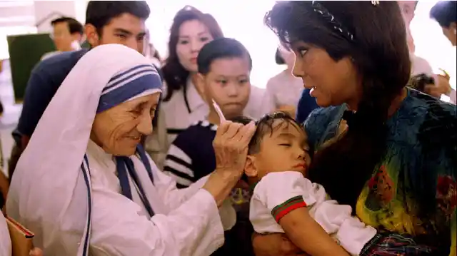 File picture of Mother Teresa blessing a sick child.