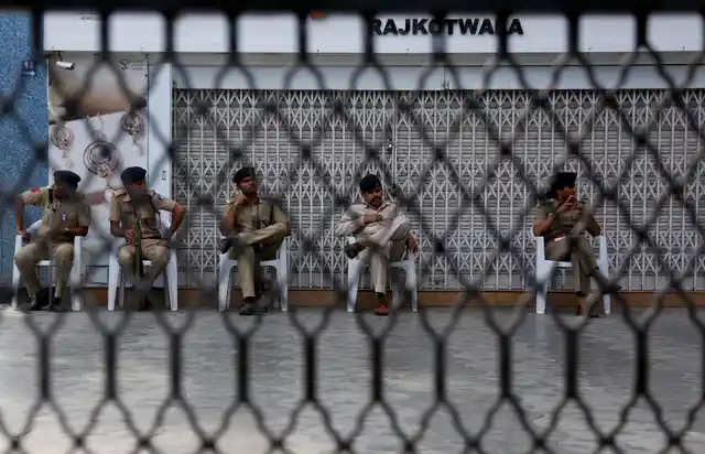 Policemen sit in front of a closed jewellery shop during a strike in Ahmadabad. Jewellers across the country had decided to go on a three-day strike from Wednesday to protest the proposed re-imposition of 1 percent excise duty. (Photo: AP Photo/Ajit Solanki)