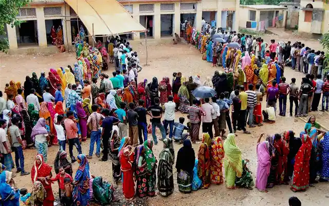 Voters stand in a long queue to cast their votes at a polling station during the 2nd part of 1st phase West Bengal Assembly Elections in Bankura. (Photo: PTI)