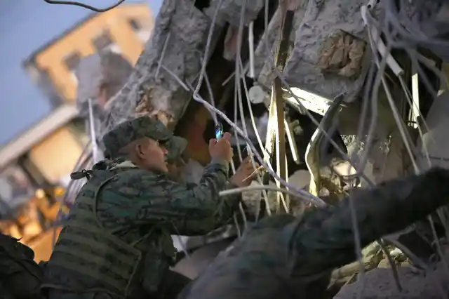 A soldier uses his mobile phone as a flashlight to search for survivors after an earthquake in Portoviejo, Ecuador. (Photo: AP)