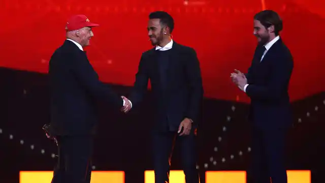 Niki Lauda with his Laureus Lifetime Achievement Award shakes the hand of Formula 1 driver Lewis Hamilton of Mercedes as actor Daniel Bruhl stands by on stage during the 2016 Laureus World Sports Awards (Photo by Tom Dulat/Getty Images for Laureus)