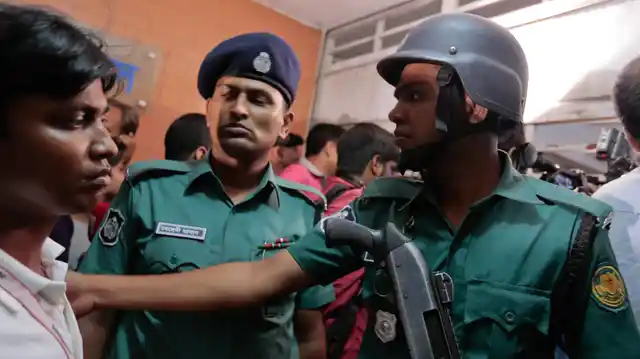 Bangladeshi policemen try to control the crowd of onlookers at a building where Xulhaz Mannan and his friend Tonoy Mahbub were found stabbed to death in Dhaka, Bangladesh, Monday 25 April 2016. (Photo: AP)