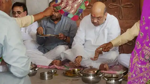 BJP President Amit Shah having a meal with a dalit family in Varansi. 