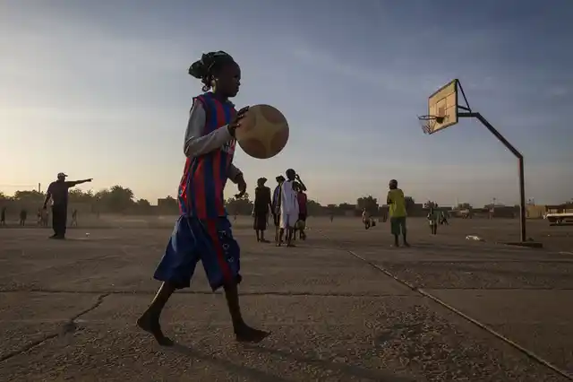 A girl practices basketball at sunset in one of Africa’s oldest trading centers, Gao, Mali. During the Jihadist occupation in 2012, girls were forbidden to practice sports and to wear shorts. Women competed for the first time only at the 1900 Olympic Games in Paris, with women from all nations participating just a few years back in 2012. (Photo: UN Photo/Marco Dormino)