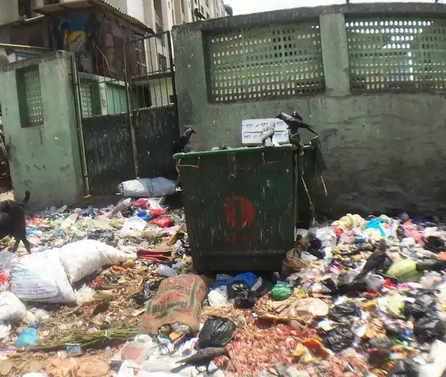 Garbage spilled around two trash cans outside a ‘redeveloped’ slum building in Nargis Nagar, Bandra (East), Mumbai. (Photo: <b>The Quint</b>/Pallavi Prasad)