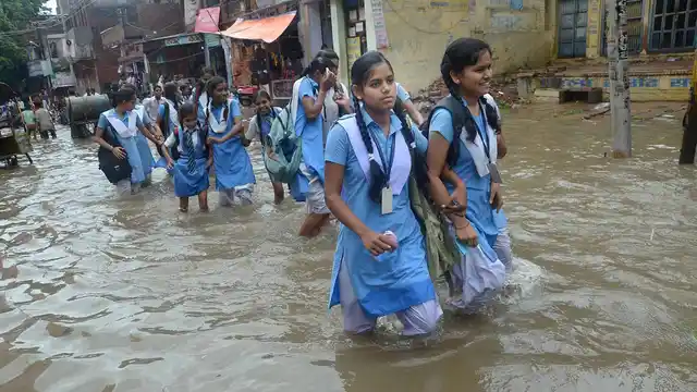 Schoolgirls wade through a water logged street after heavy rains in Mirzapur in early July. 