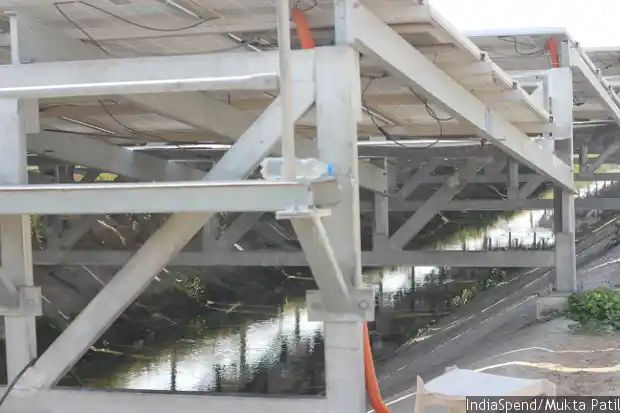 The panels placed at optimum angle over canal water. When they are cooled from below, their efficiency increases and enhances output by 2.5-5 percent. (Image Courtesy: IndiaSpend/Mukta Patil)