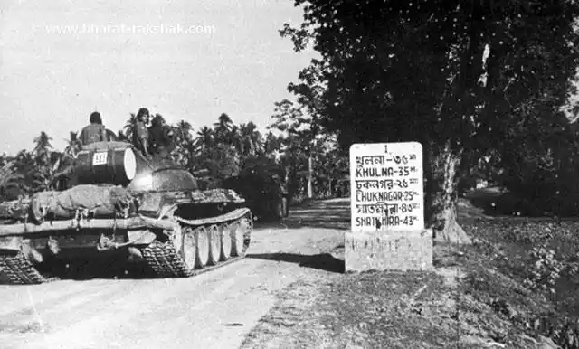 An Indian T-55 tank of ‘B’ Squadron, 63 Cavalry, leading the road to Khulna from Jessore - 35 miles away, says the stone post at left. It was not a cake walk, as the Pakistan Army put up a stiff and determined opposition at Khulna.