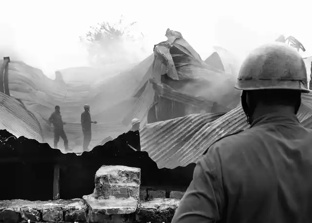 A fireman looks at his fellow colleagues as they try to put down the fire. (Photo courtesy: Sameer Khan)