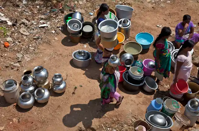 Women gather with utensils to collect water from a public tap on the outskirts of Hyderabad. (Photo: AP)