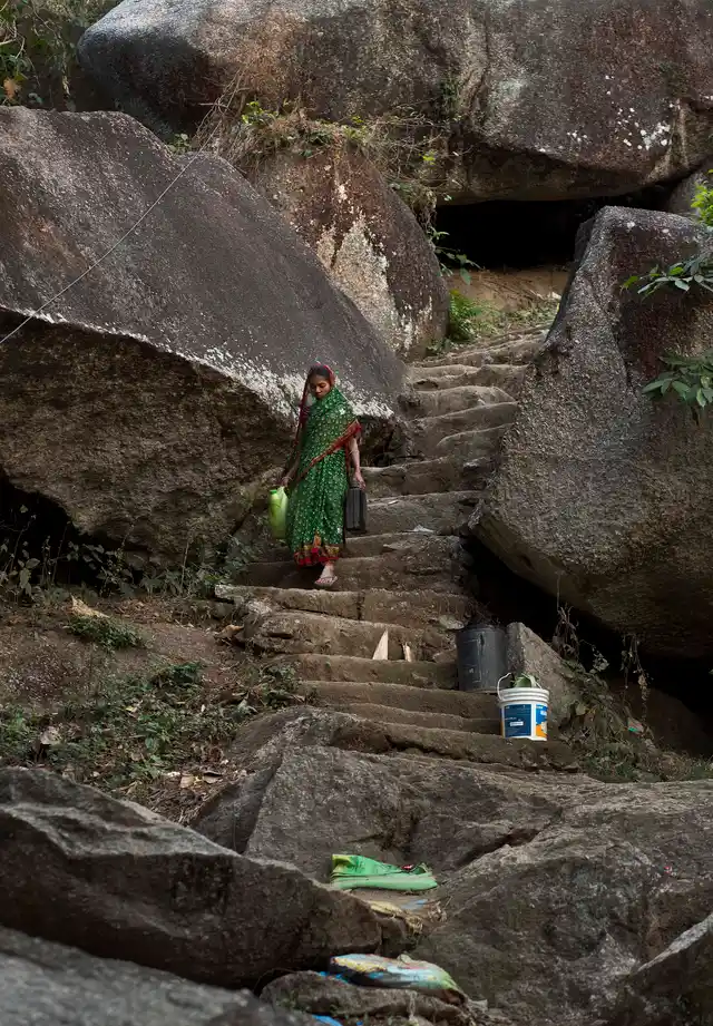 A woman walks down a hill to collect drinking water from a public water tap in Guwahati. (Photo: AP)