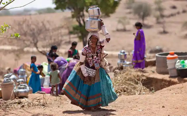 A woman in her traditional attire walks after collecting water from public tap on the eve of World Water Day on the outskirts of Hyderabad. (Photo: AP)