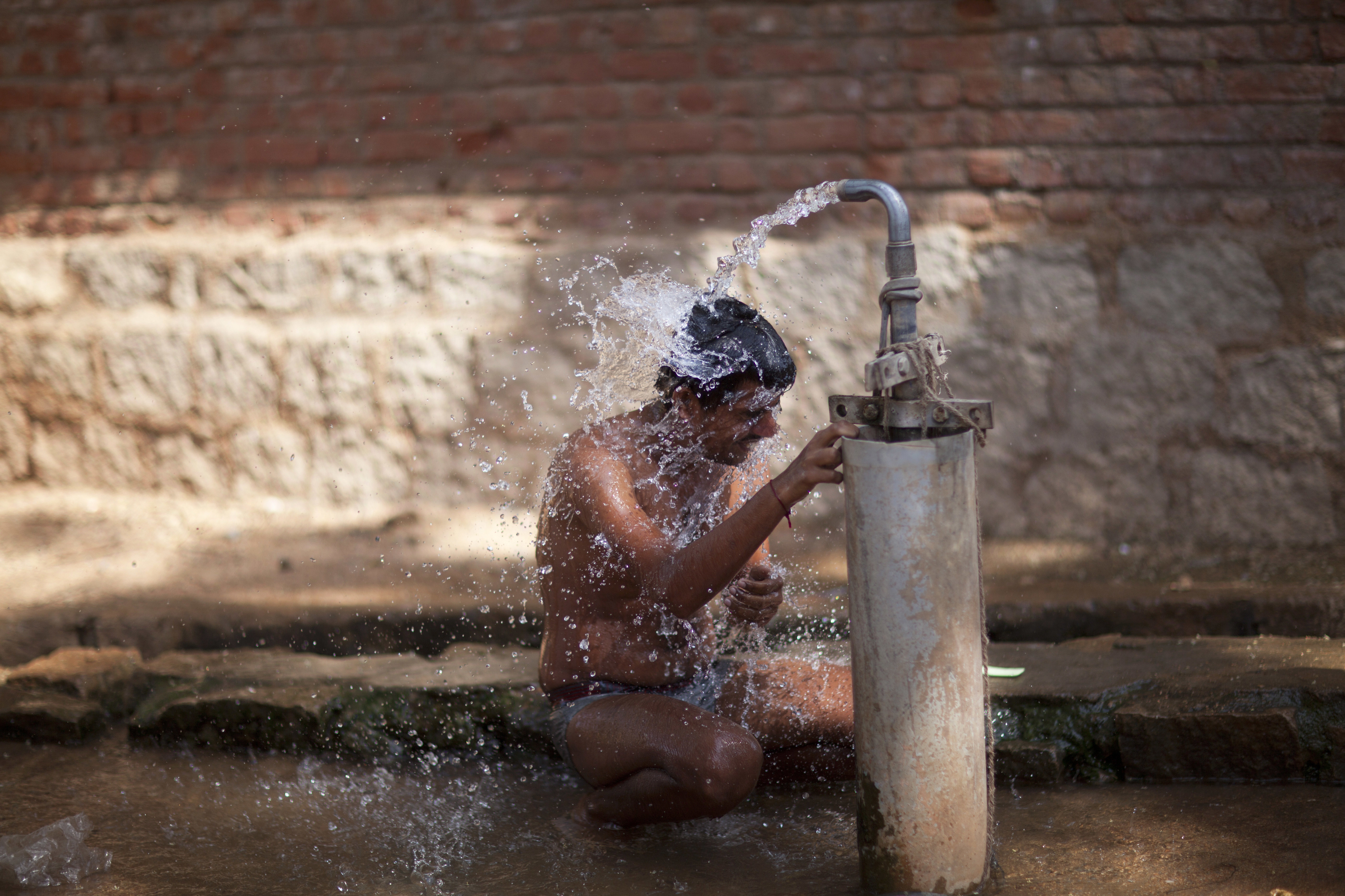 A man takes bath at a public tap on the eve of World Water Day on the outskirts of Hyderabad. (Photo: AP)