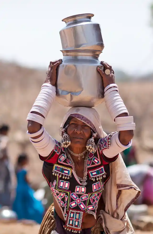 A woman in her traditional attire walks after collecting water from public tap on the eve of World Water Day on the outskirts of Hyderabad on 21 March 2017. (Photo: AP)