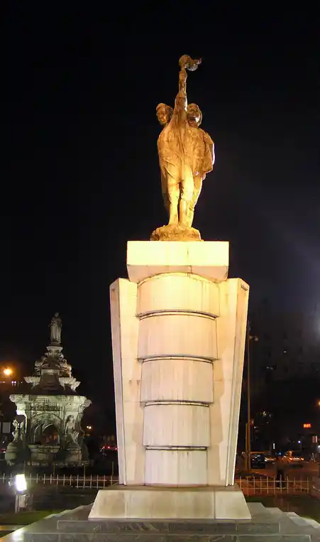 Flora Fountain was renamed Hutatma Chowk (“Martyr’s Square”) as a memorial to the Samyukta Maharashtra movement. The Hutatma Chowk memorial with the Floral Fountain, on its left in the background. (Photo Courtesy: <a href="https://en.wikipedia.org/wiki/Hutatma_Chowk#/media/File:Hutatma_Chowk.jpg">Wikipedia</a>)
