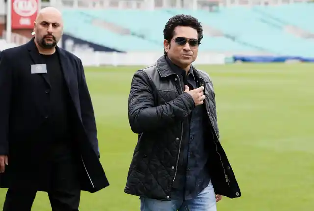 Sachin Tendulkar is escorted by a security officer as he arrives at the Oval cricket ground. (Photo: AP)