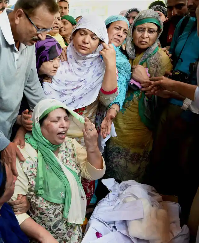 Mohd Ayud Pantih’s relatives cry near his coffin at his residence in Srinagar on Friday. 