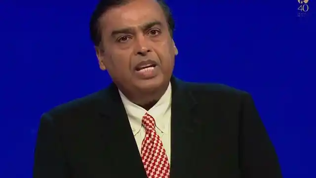 Mukesh Ambani is on stage briefing the media. 