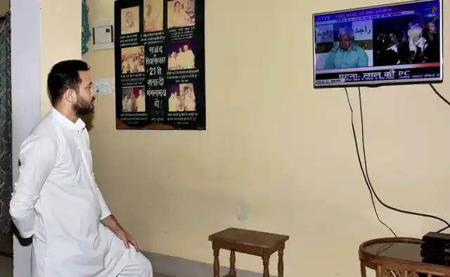 Bihar Deputy Chief Minister Tejashwi Yadav watching TV after Nitish Kumar resigned as Chief Minister in Patna on Wednesday.