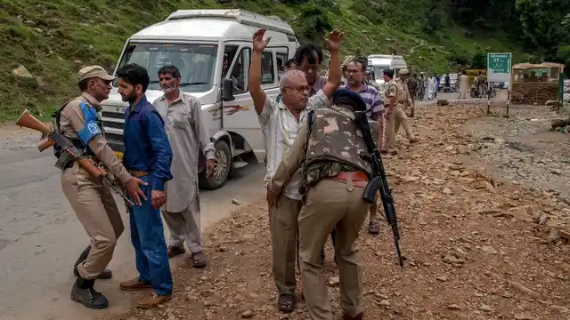 CRPF personnel frisk a Kashmiri civilian (left) and an Indian pilgrim (right) at a temporary checkpoint near the base camp in Pahalgam, Kashmir, 11 July 2017.
