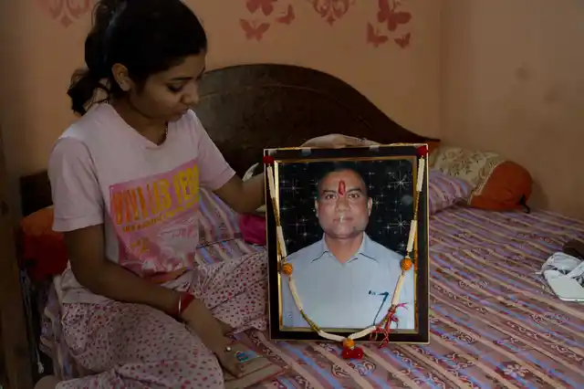 Shruti holds up her father’s portrait. She hasn’t been able to continue her studies ever since Ravi’s death. 