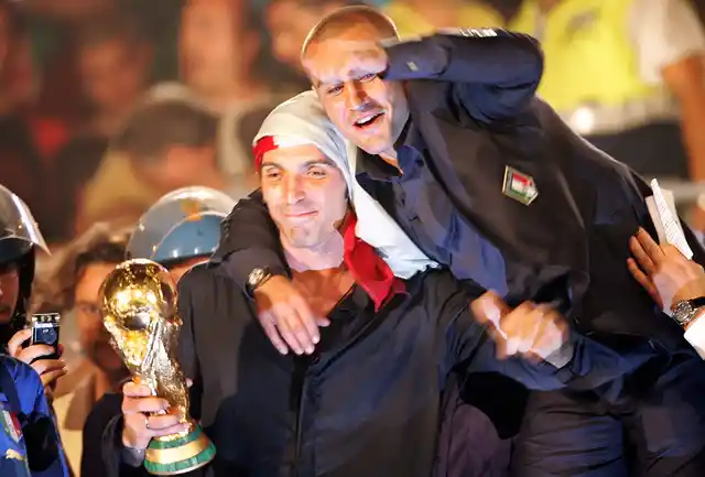 10 July 2006 photo of Gianluigi Buffon (L) and Fabio Cannavaro celebrating with the World Cup trophy during celebrations at the Circus Maximus in downtown Rome 