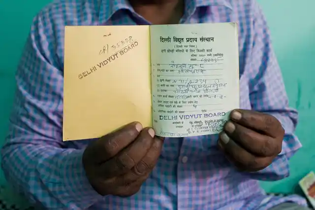 Rohtash Kumar a resident of Chandrawal Basti shows his yellow card.