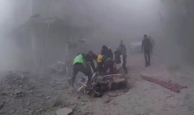 Civil Defense workers carry an injured man after government airstrikes hit Douma, near Damascus, Syria