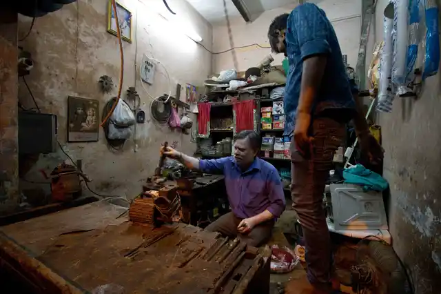 Nand Kishor and his son Vishal at their small electric repair shop in Chandrawal, north Delhi.