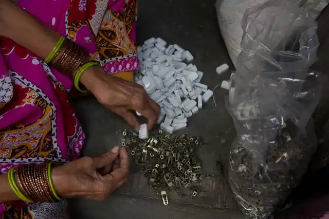 Nathu Devi putting together plastic switch covers inside her home in Kabir Nagar, north Delhi.