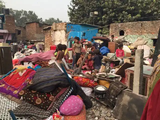 Settlers of Kathputli colony sit beside their belongings after their houses were demolished on 30 October.
