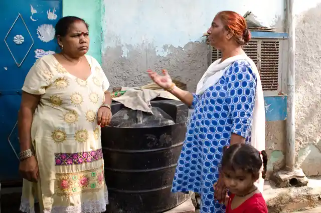 Abha worker Mehender Kaur tries to calm Hardeep Kaur who wants her meter to be shifted on the wall outside her home. The place where the metre is currently placed has water seepage.