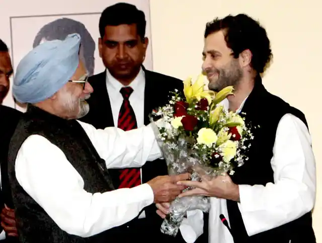 Former Prime Minister Manmohan Singh hands a bouquet to Rahul Gandhi, on his appointment as the vice president of the Indian National Congress.