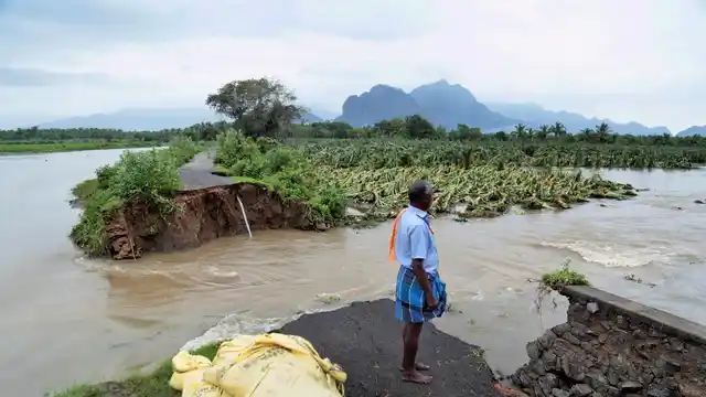 A man looks at one of the many roads damaged by Cyclone Ockhi.