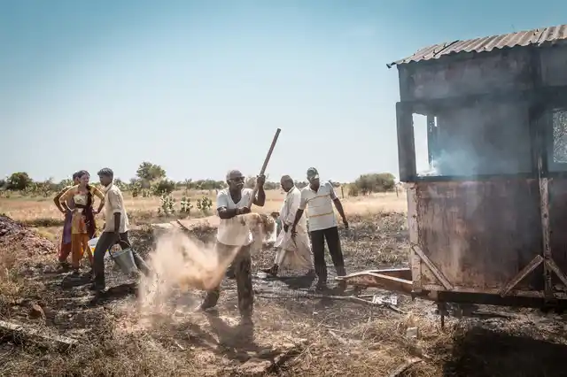 Despite their differences, forest guards and villagers work together to douse a small fire in Sudasari.