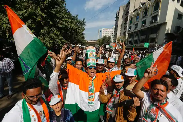 Supporters of the Congress celebrate outside a counting centre in Ahmedabad on 18 December.