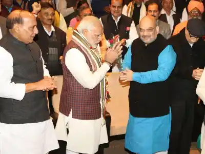 New Delhi: BJP president Amit Shah greets Prime Minister Narendra Modi during the BJP Parliamentary Party meeting at Parliament House in New Delhi on Dec. 20, 2017. Also seen Union Minister Rajnath Singh and other leaders. (Photo: Amlan Paliwal/IANS)