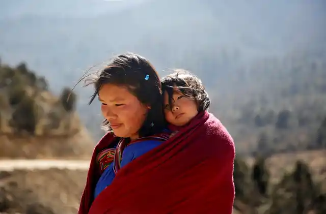 A woman carries her daughter near Punakha, Bhutan, 14 December 2017. 