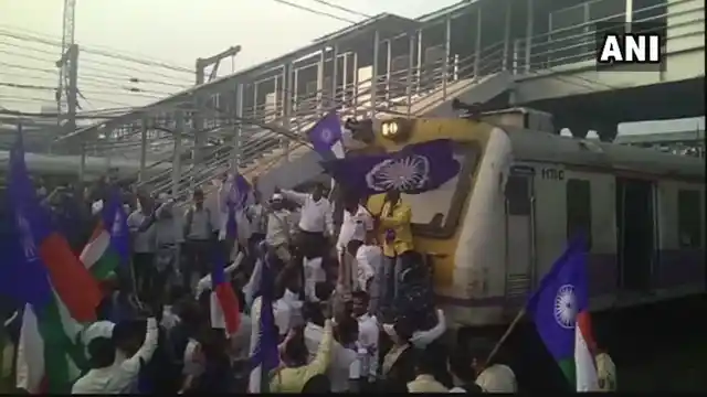 Protesters stop a train at Thane railway station.