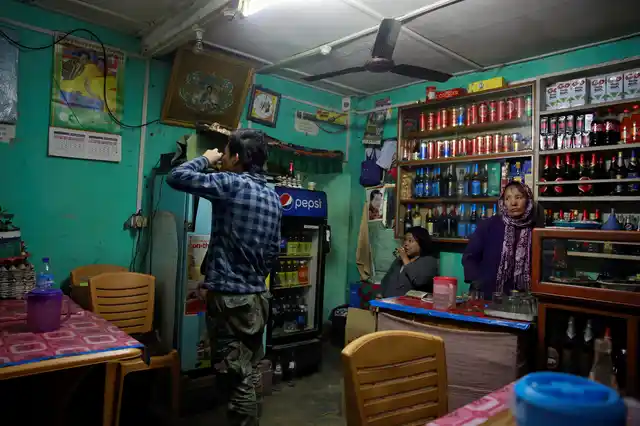 A youth drinks whiskey at a bar in the capital city of Thimphu, Bhutan, 16 December 2017. 